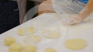 Close up of the happy smiled grandmother and grandson kneading a daugh together. slow motion of an elderly woman and