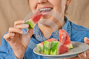 Close-up of a happy smiling Caucasian woman holding a slice of watermelon with her hand. Front view. Low angle view