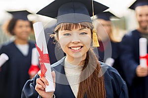 Close up of happy student or bachelor with diploma