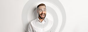 Close-up of happy and surprised man looking left with excitement, white background