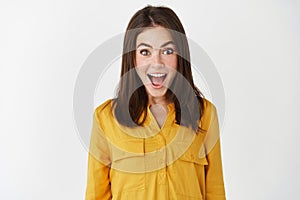 Close-up of happy and surprised woman open mouth and staring with disbelief, receive good news, express amazement while