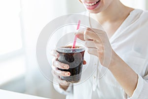 Close up of happy woman drinking coca cola