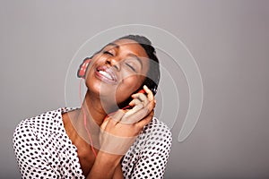 Close up happy woman listening to music on headphones with eyes closed