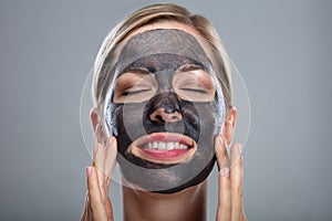 Happy Woman Using Activated Charcoal Face Mask