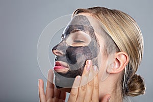 Happy Woman Using Activated Charcoal Face Mask