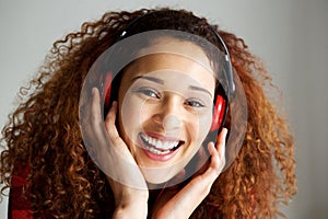 Close up happy young african american woman smiling and listening to music with headphones