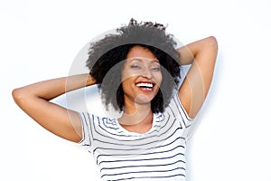 Close up happy young black woman with hands behind hair and smiling on white background