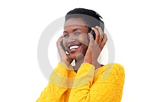 Close up happy young black woman listening to music with headphones by white background