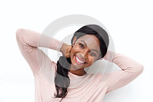 Close up happy young black woman smiling with hands behind head against white background