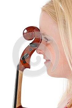 Close up of happy young blonde girl with the head of a violin pressed against the bridge of her nose