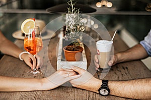 Close up of happy young couple holding hands on table