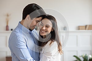 Close up happy young couple hugging, enjoying tender moment