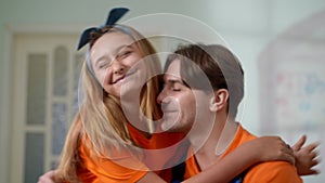 Close-up happy young father hugging daughter entering living room under repair. Smiling handsome Caucasian man embracing