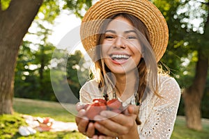 Close up of happy young girl in summer hat spending time at the park,
