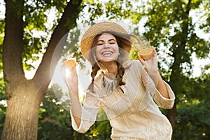 Close up of happy young girl in summer hat spending time at the park,