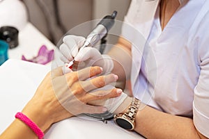 Close-up hardware manicure in salon. Removal of old gel varnish.