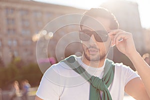 Close up of a harsh young brunete guy, walking in the city outdo