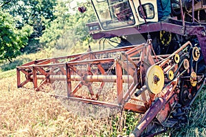 Close-up of harvesting combine in grain and wheat crops