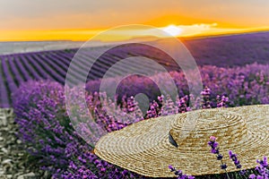 Close-up of a hat on lavender flowers on a sunset background. Love in the lavender concept