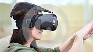 Close-up head of astonished young woman wearing virtual reality glasses playing in vr game