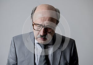 Close up head portrait of bald 60s senior business man sad and depressed looking desperate and feeling low in sadness emotion