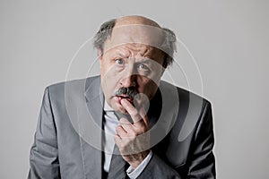 Close up head portrait of bald 60s senior business man sad and depressed looking funny and messy in sadness emotion