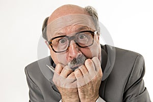 Close up head portrait of bald 60s senior business man surprised and scared looking as if big mistake or disaster in the office