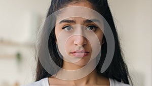 Close up head shot frustrated sad lonely Indian ethnic woman businesswoman looking at camera pensive anxious sight