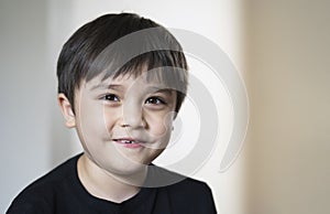 Close up head shot kid looking at camera with smiling face with copy space, Healhty child with happy face with blurry background.