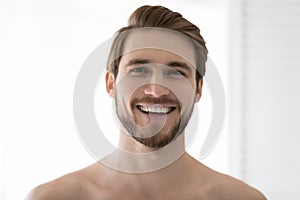 Happy young 30s guy feeling refreshed after showering. photo