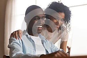 Close up head shot young mixed race family couple watching comedian movie.