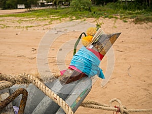 Close up head of squid fishing boat on in the cloudy morning day, with flower and joss stick for lucky