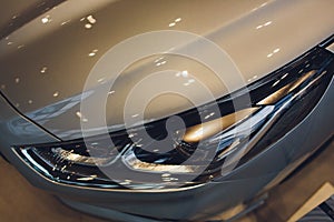 Close up of headlight detail of modern luxury car with projector lens for low and high beam. Front view of sport