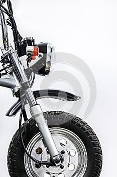 Close up of headlight and front wheel on vintage motorcycle. Custom scrambler motocross. Retro motorbike on white background. photo