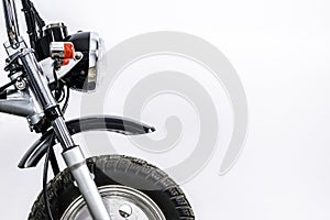 Close up of headlight and front wheel on vintage motorcycle. Custom scrambler motocross. Retro motorbike on white background.