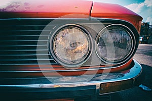 Close-up of headlight of a red vintage classic car