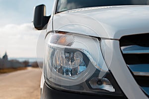 Close-up of headlight of white car outdoors