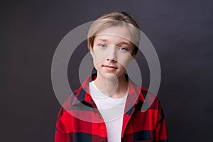 Close-up headshot of confident concentrated young man in plaid shirt looking