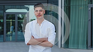 Close-up headshot confident serious concentrated Indian Arabic young man wearing shirt stand posing with arms crossed