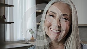 Close up headshot of female senior old grey-haired lady mature caucasian blonde grandmother 60s age generation housewife
