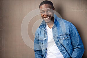 Close up headshot of a handsome african american man, stylish, cool, hip, casual jean jacket, with white teeth