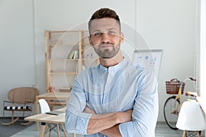 Close up headshot portrait picture of smiling businessman crossing hands.