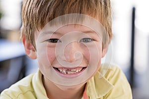 Close up headshot portrait of young little 7 or 8 years old boy with sweet funny teeth smiling happy and cheerful in joy face expr