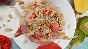 Close up of a healthy cereal and dry strawberry dropping in to bowl. Pabulum. photo