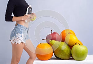 Close up of healthy girl with perfect buttocks and thighs. Slim body of young woman. Fruits diet.