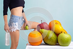 Close up of healthy girl with perfect buttocks and thighs. Slim body of young woman. Fruits diet.