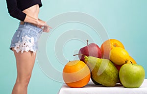 Close up of healthy girl with perfect buttocks and thighs. Slim body of young woman. Fruits diet.