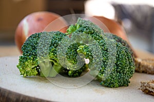 Close-up of healthy vegetarian food, vegetables - green broccoli and bread in the kitchen placed on wooden table