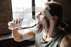 Close up of a healthy young fitness man drinking water