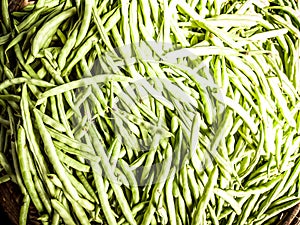 Close-up heap of pile raw green beans on a local asia farmers market. Cooking and healthy food concept, vitamins for